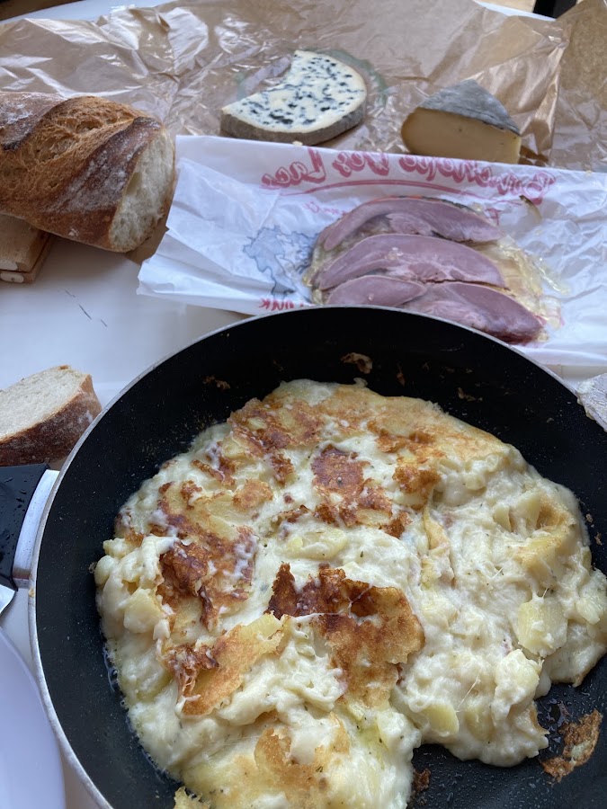 Jambon tranché sur le papier de la boucherie, avec pain et fromages du pays